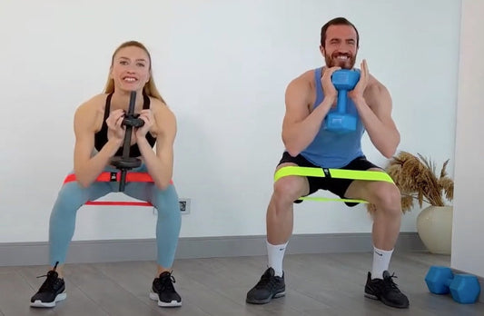 Kadın ve erkek direnç bandı ile dumbbell goblet squat yapıyor | Man and woman performing resistance band goblet squat with dumbbells.